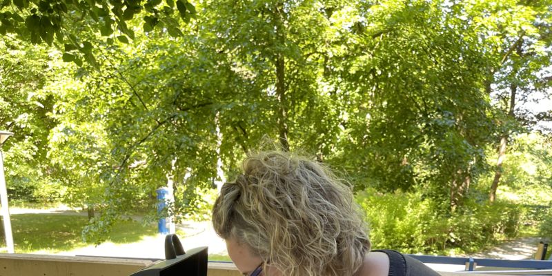 Das Foto zeigt eine Frau, die eine Bratwurst zerschneidet.