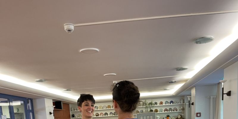 Das Foto zeigt zwei Frauen, die sich lachend unterhalten.