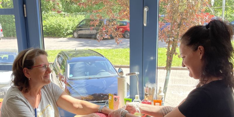 Auf dem Foto sind zwei Frauen bei der Maniküre zu sehen.